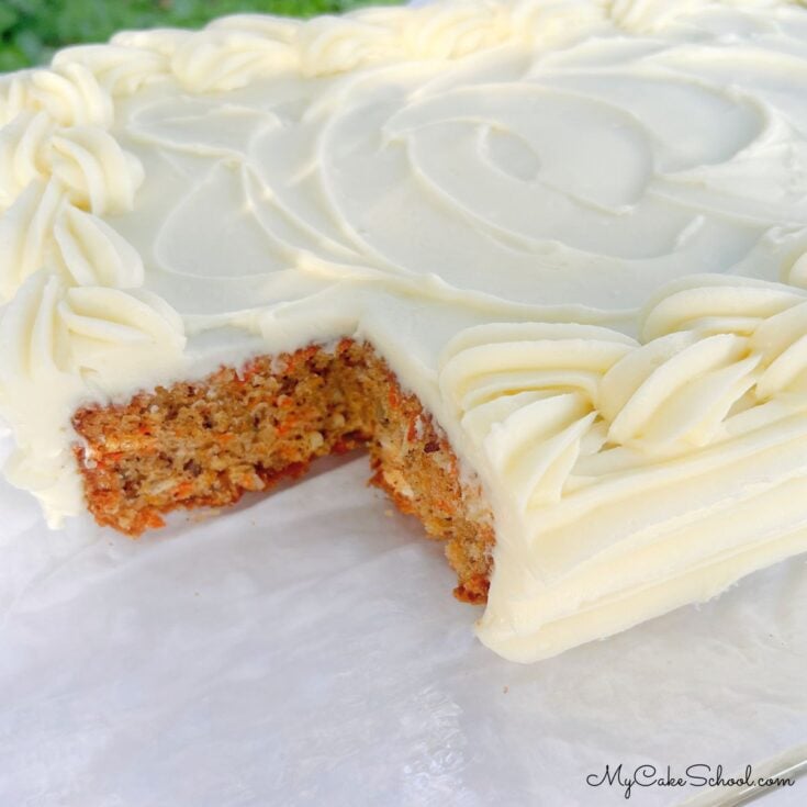 Carrot Sheet Cake, sliced, on a cake platter.