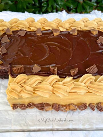 Chocolate Sheet Cake with Peanut Butter frosting, sliced, on a cake plate.