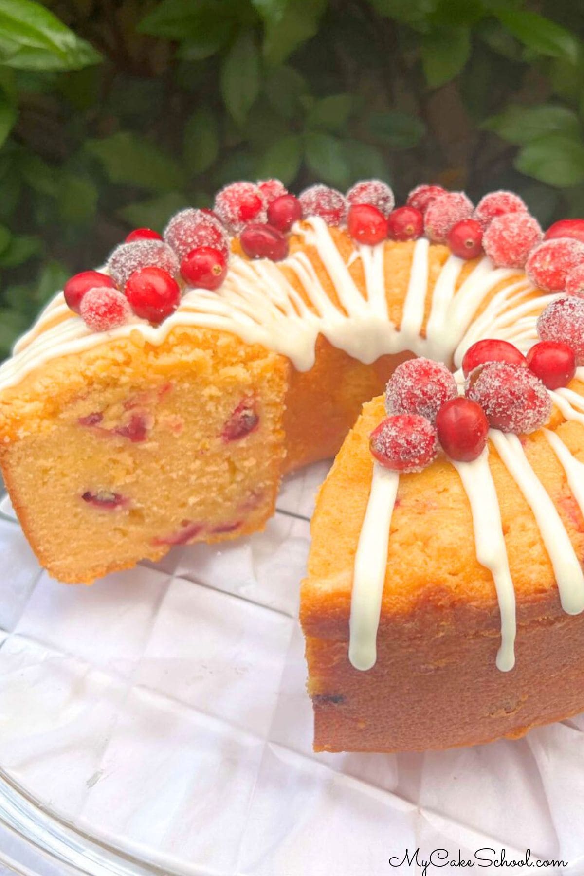 Cranberry Orange Pound Cake, sliced, on a cake platter.