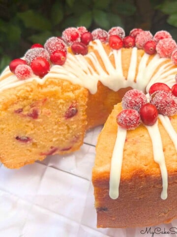 Cranberry Orange Pound Cake, sliced, on a cake plate.