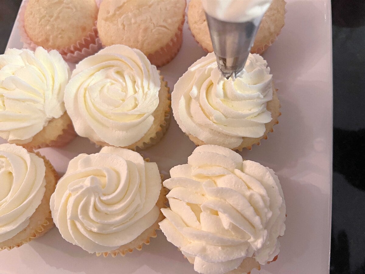 Piping the Whipped Coconut Cream Cheese Frosting.