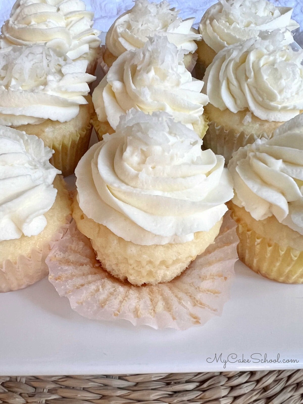 Moist easy Coconut Cupcakes on a cake platter.