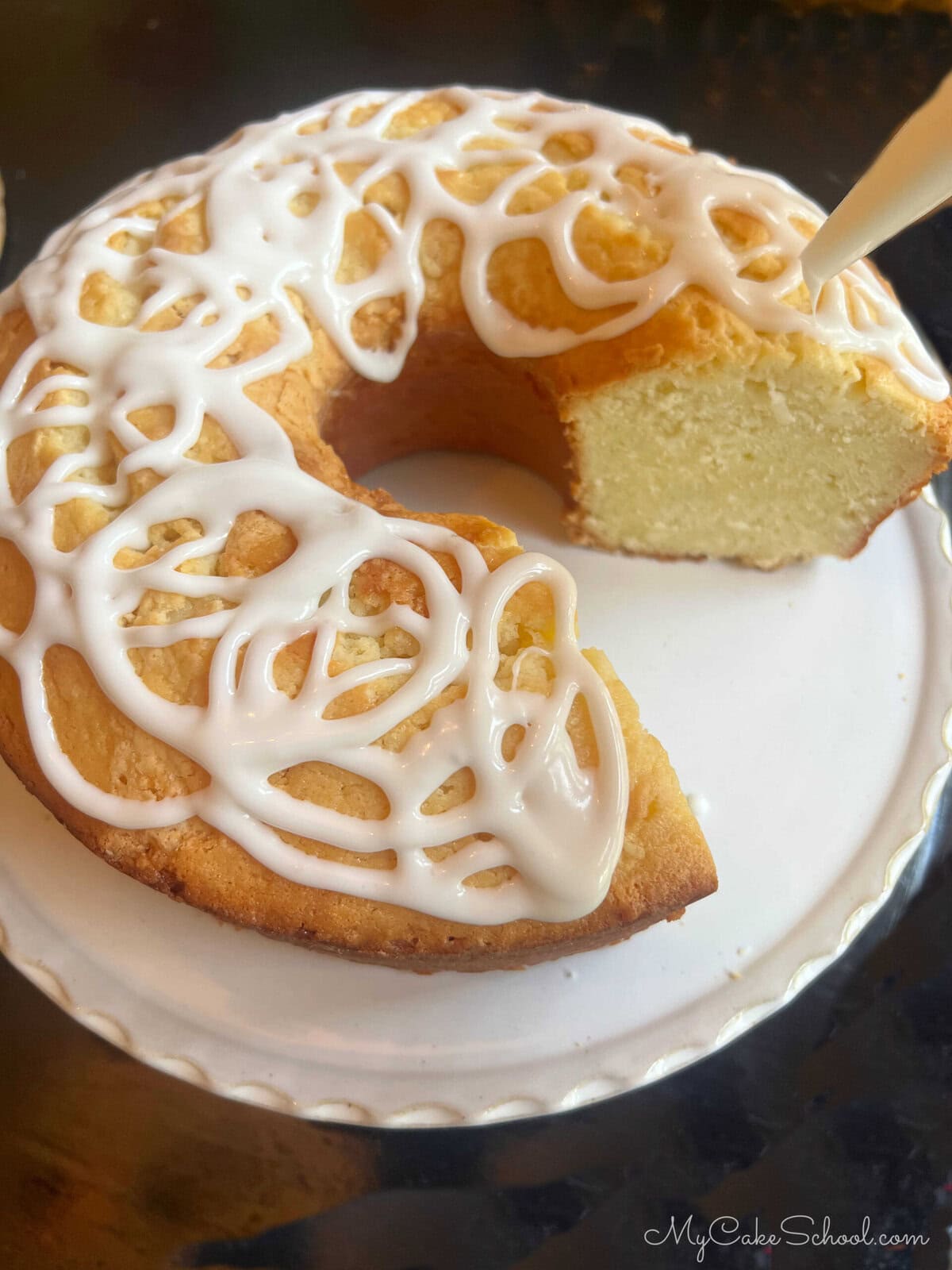 Piping glaze over the pound cake.