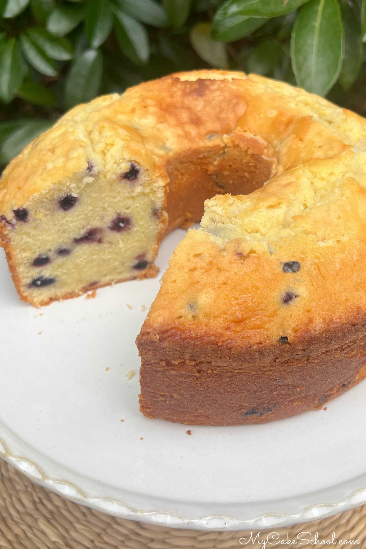 Lemon Blueberry Mascarpone Cake, sliced, on a pedestal.