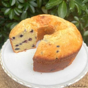 Lemon Blueberry Mascarpone Pound Cake, sliced, on a pedestal.