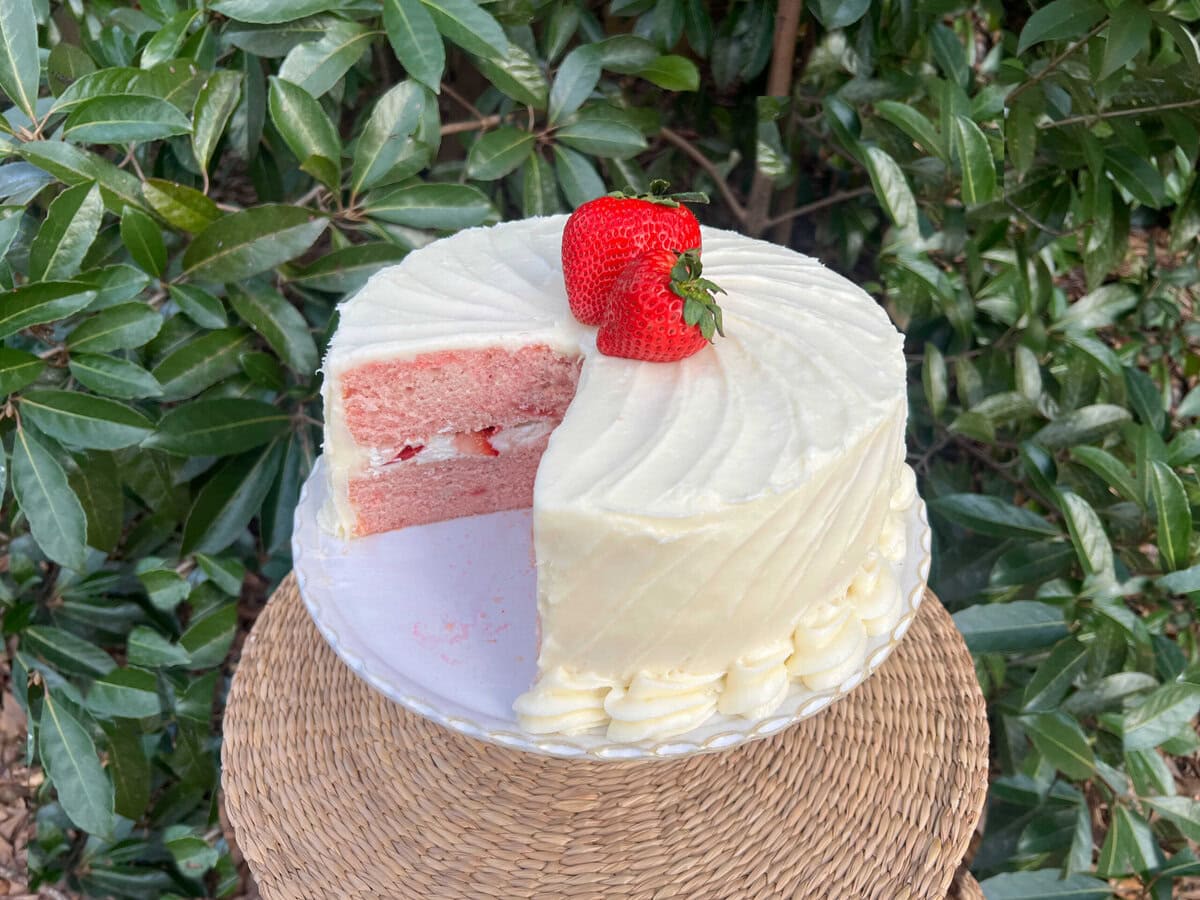 Sliced Strawberry Velvet Cake on a pedestal.