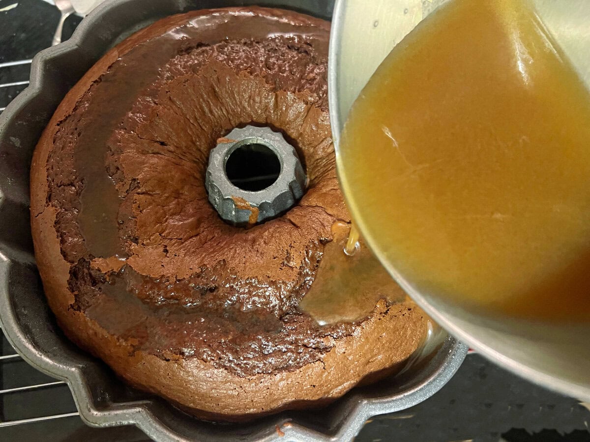 Pouring glaze over the freshly baked cake.