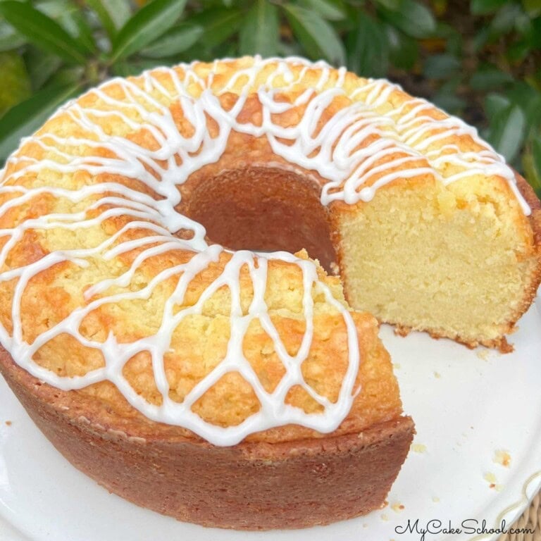 Coconut Whipping Cream Pound Cake, sliced, on a cake pedestal.