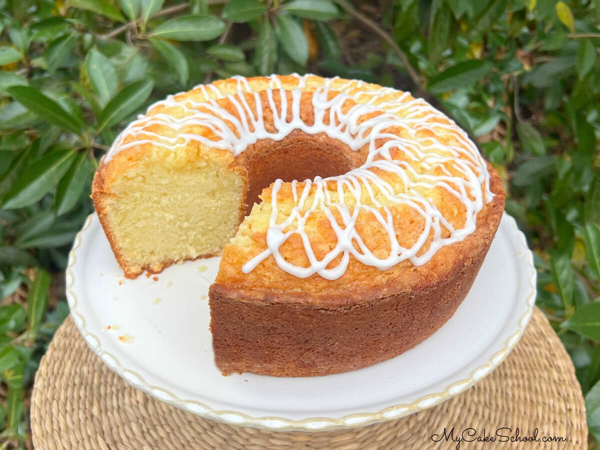 Coconut Whipping Cream Pound Cake, sliced, on a pedestal.