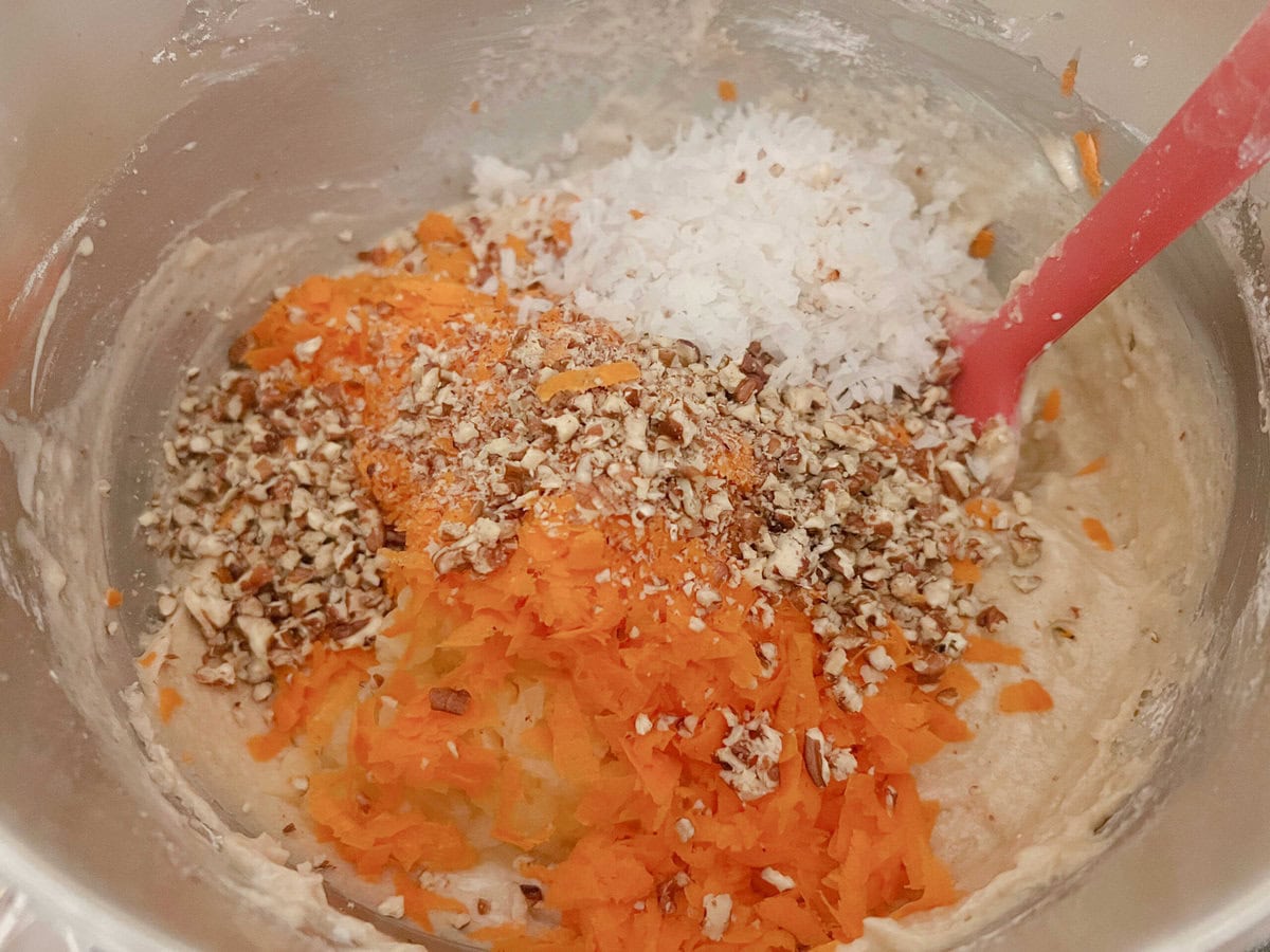 Mixing bowl, adding in the coconut, carrots, crushed pineapple, and pecans.