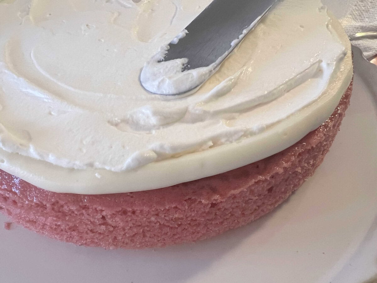 Raspberry Velvet Cake layer, topped with whipped cream.