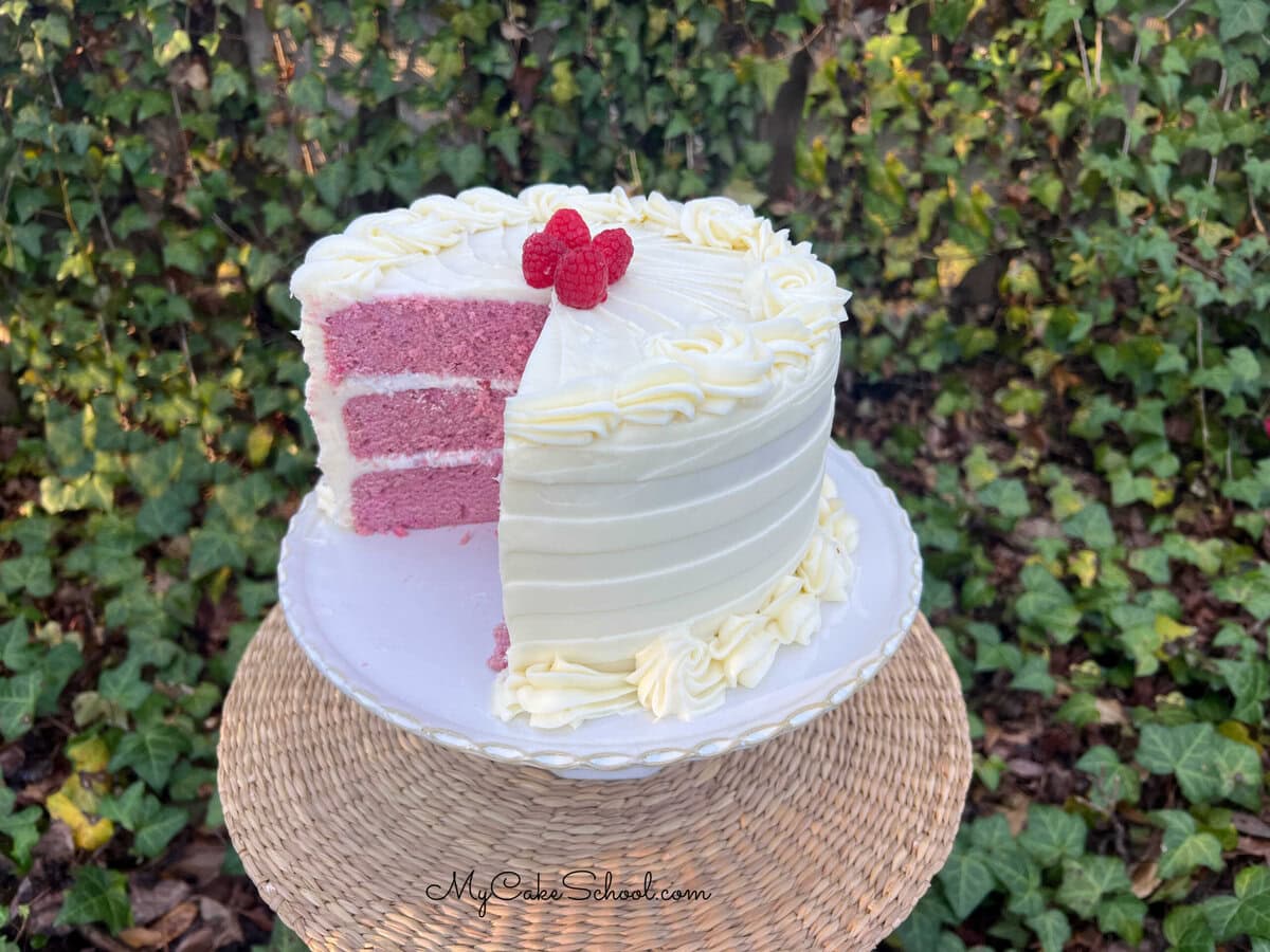 Raspberry Velvet Cake, sliced, on a cake pedestal.