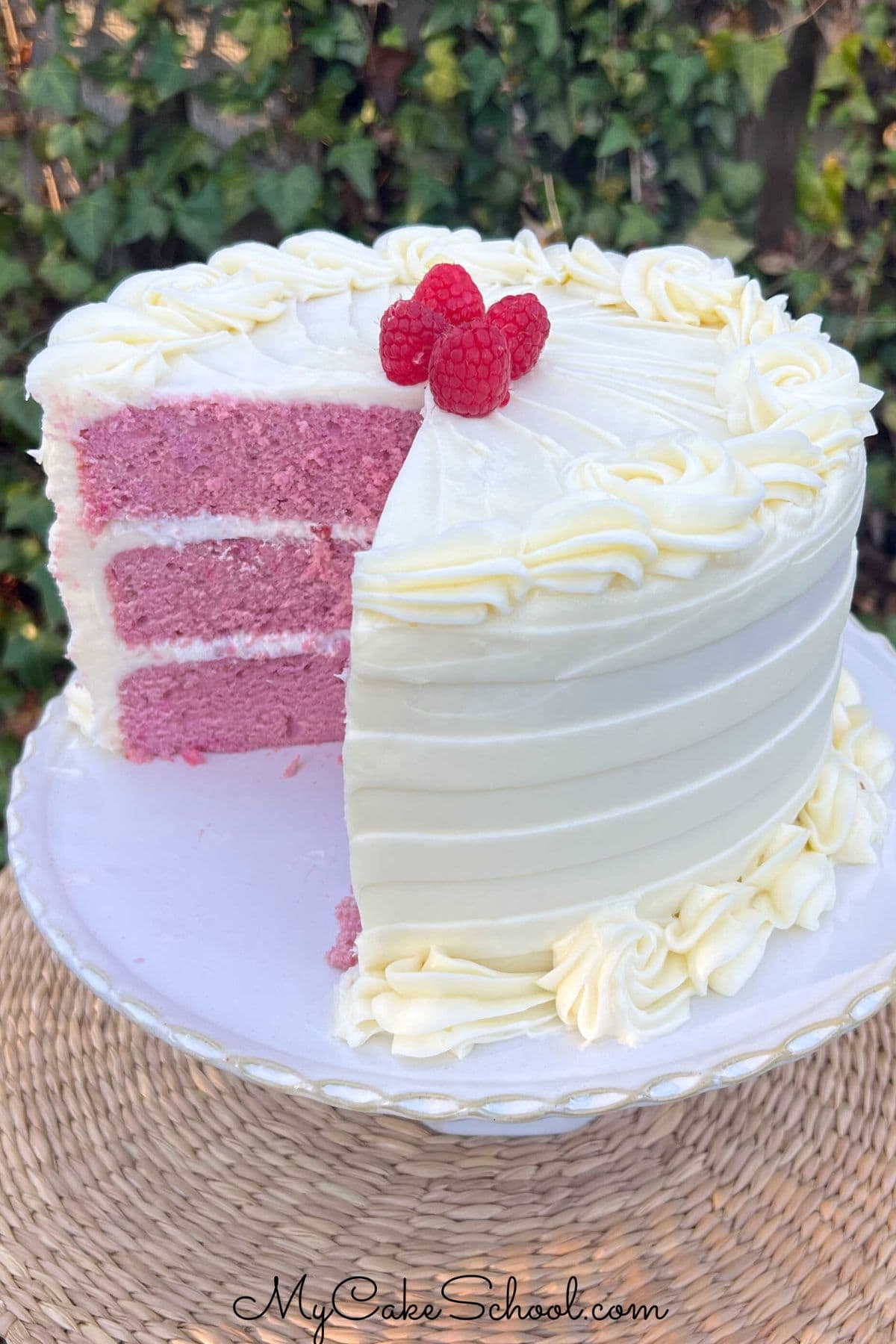 Raspberry Velvet Cake, sliced, on a pedestal.