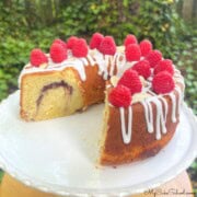 Raspberry Almond pound Cake, sliced, on a cake pedestal.