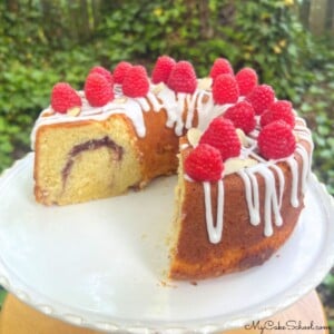 Raspberry Almond pound Cake, sliced, on a cake pedestal.