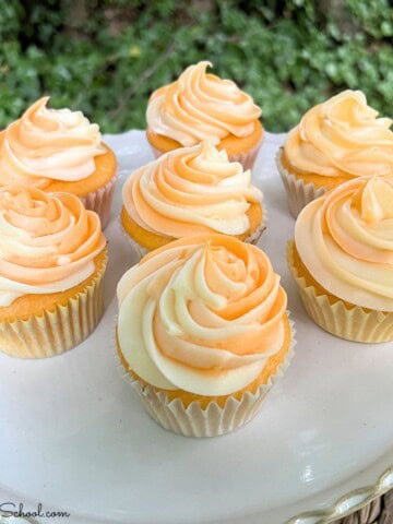 Orange Creamsicle Cupcakes on a cake platter.