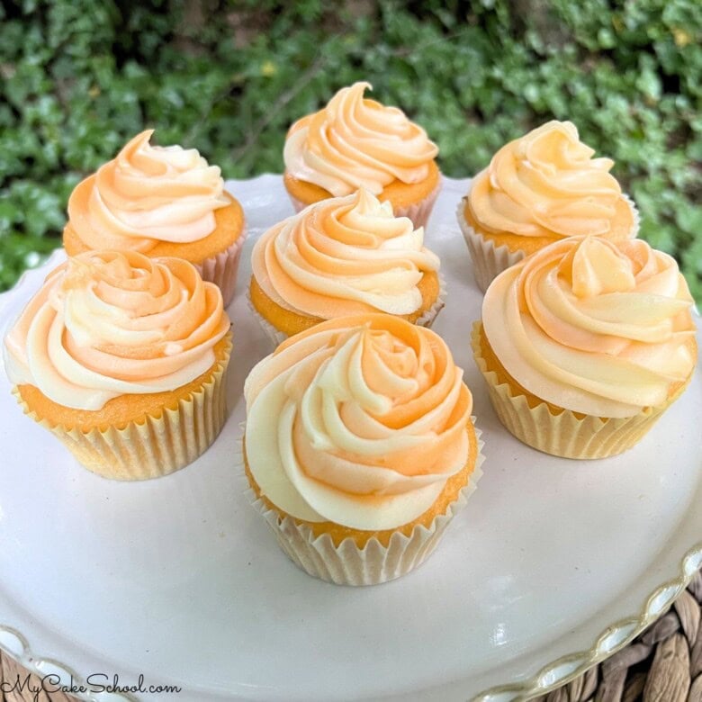 Orange Creamsicle Cupcakes on a cake platter.