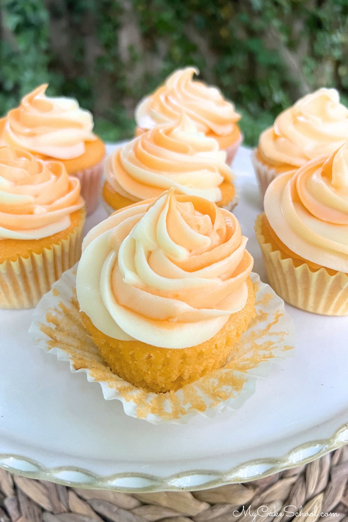 Orange Creamsicle Cupcakes on a pedestal.