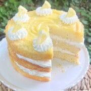 Layered Lemon Cream Cake, sliced, on a pedestal.
