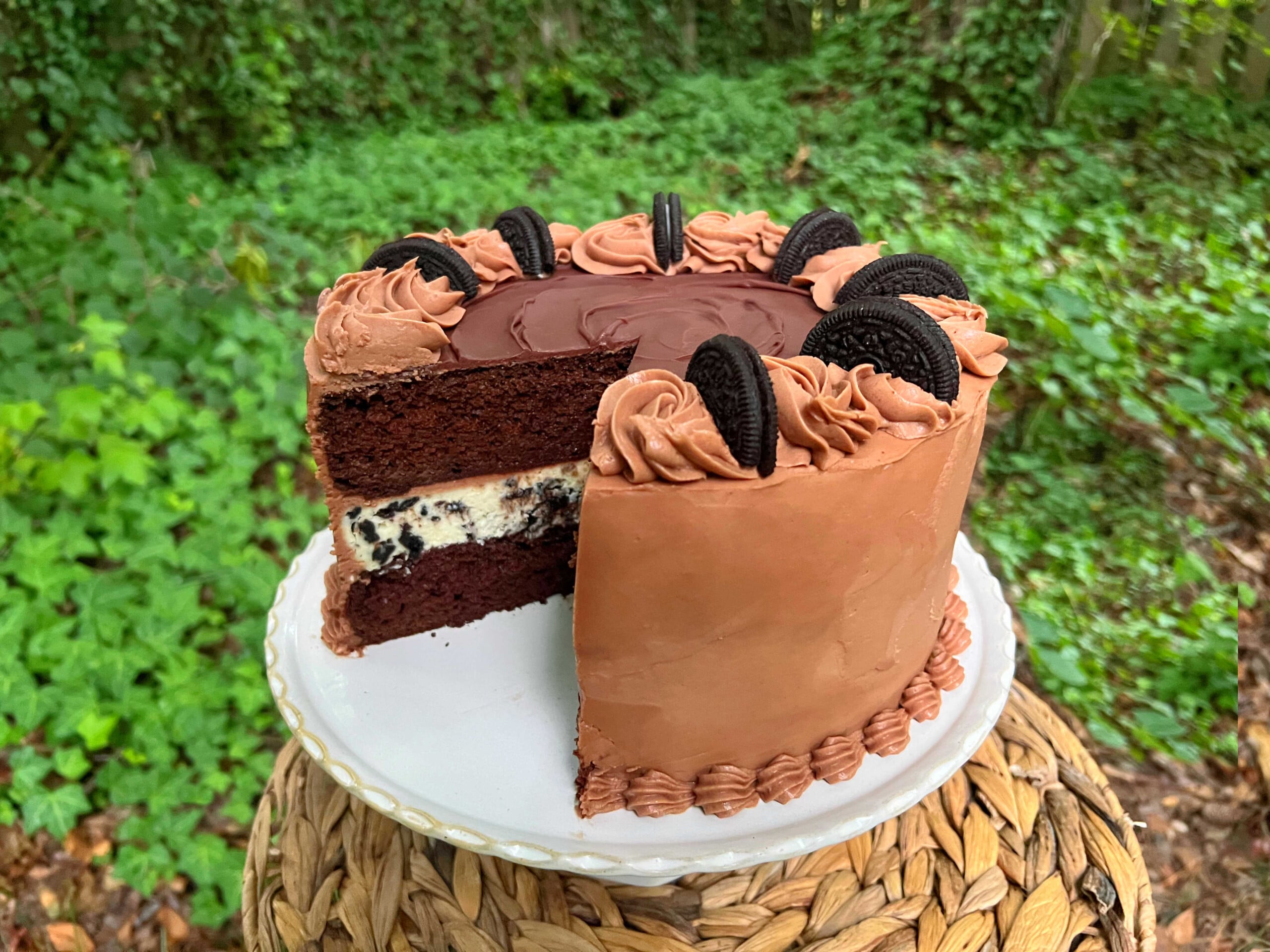 Oreo Cheesecake Cake, sliced, on a pedestal.