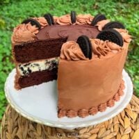 Oreo Cheesecake Cake, sliced on a pedestal.