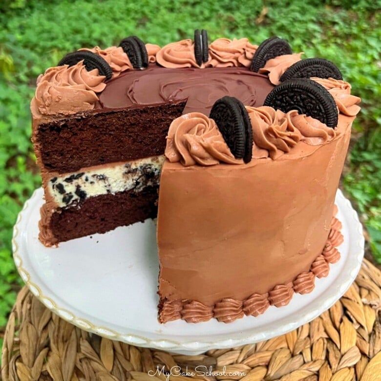 Oreo Cheesecake Cake, sliced on a pedestal.