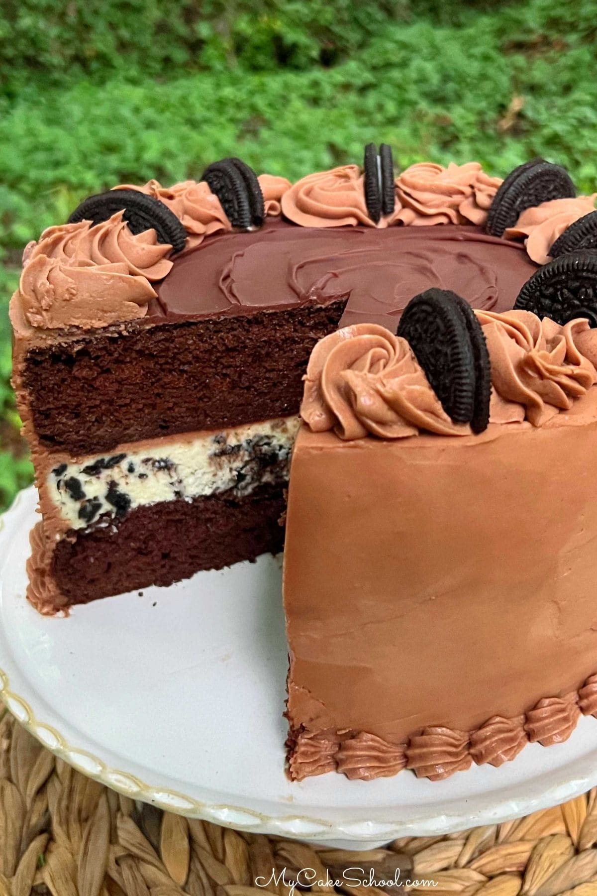 Oreo Cheesecake Cake, sliced, on a pedestal.