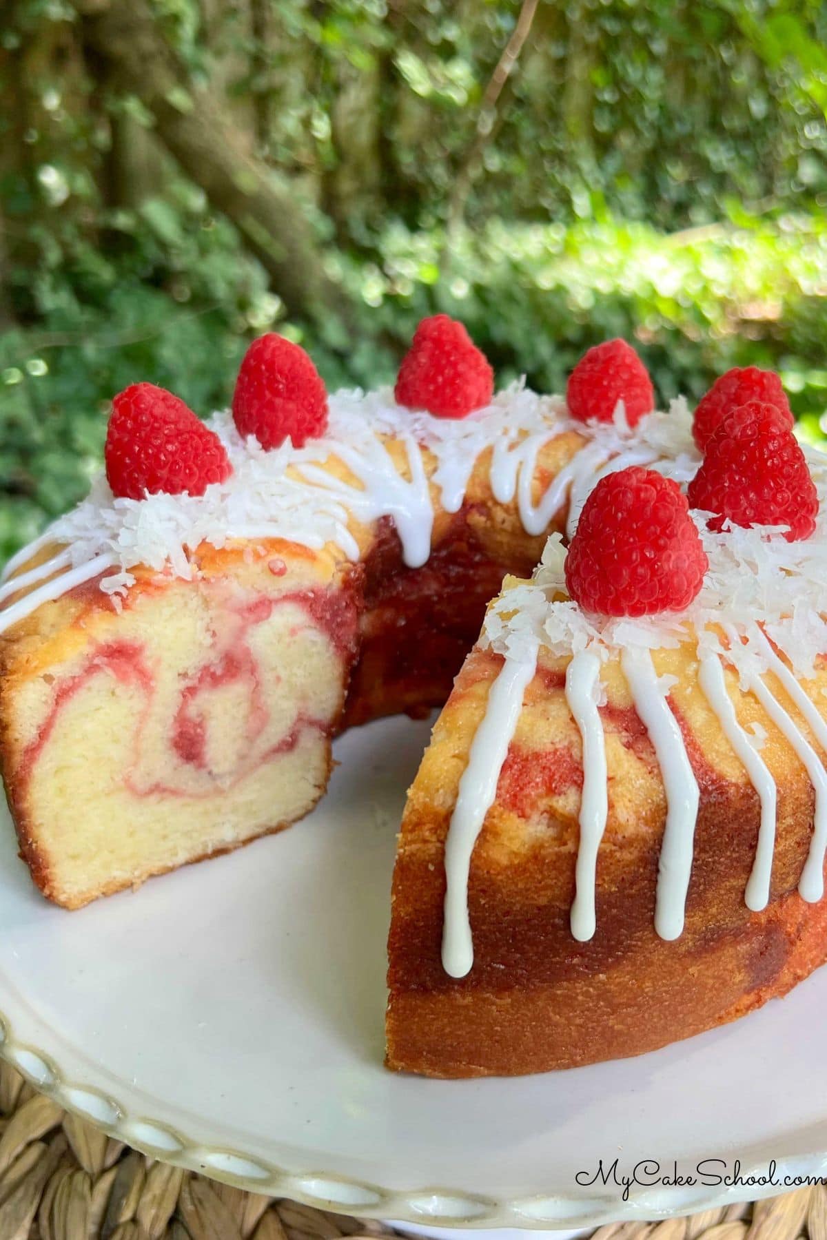 Raspberry Coconut Pound Cake, sliced, on a pedestal.