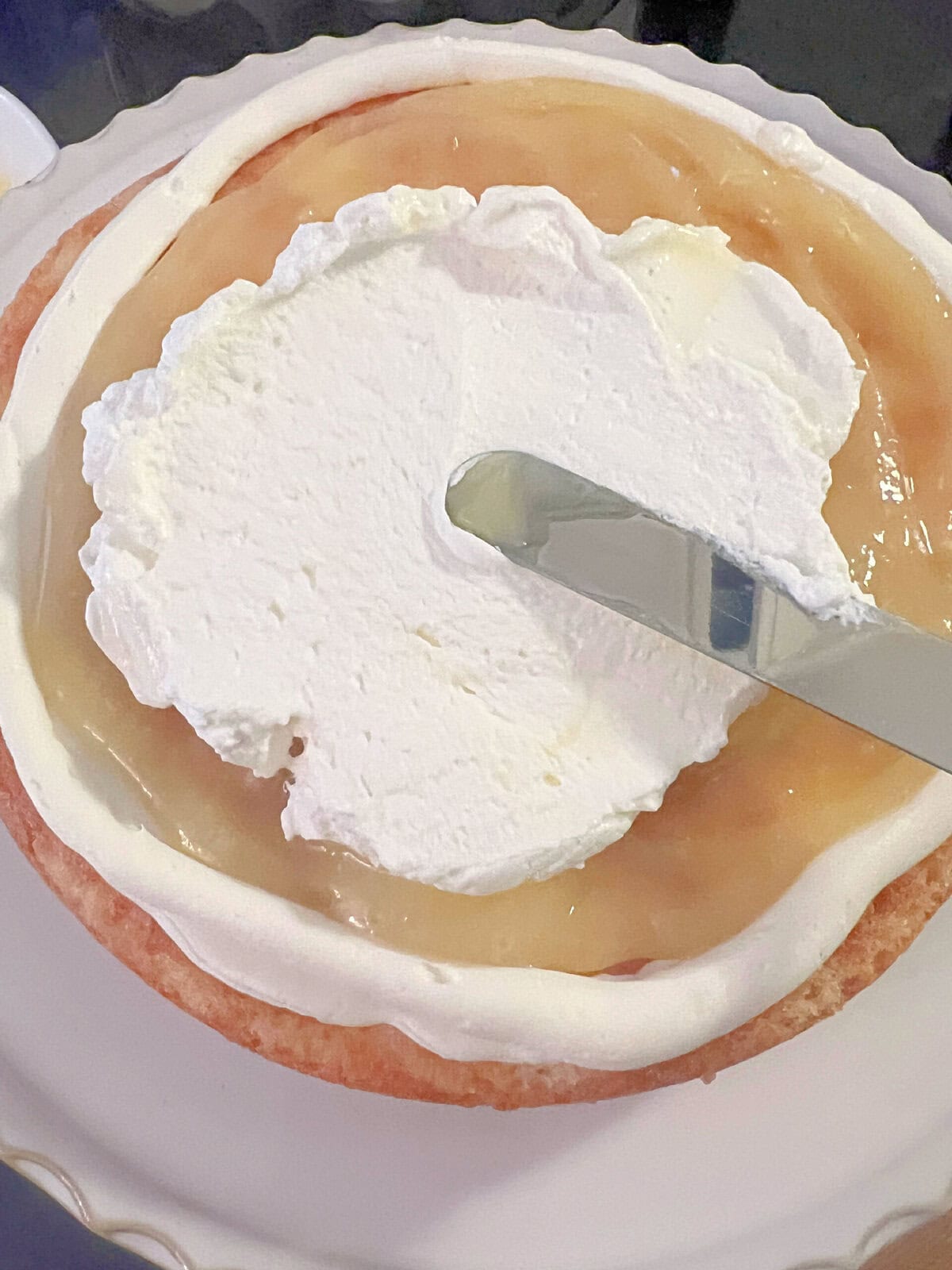 Filling the cake with lemon curd and whipped cream.