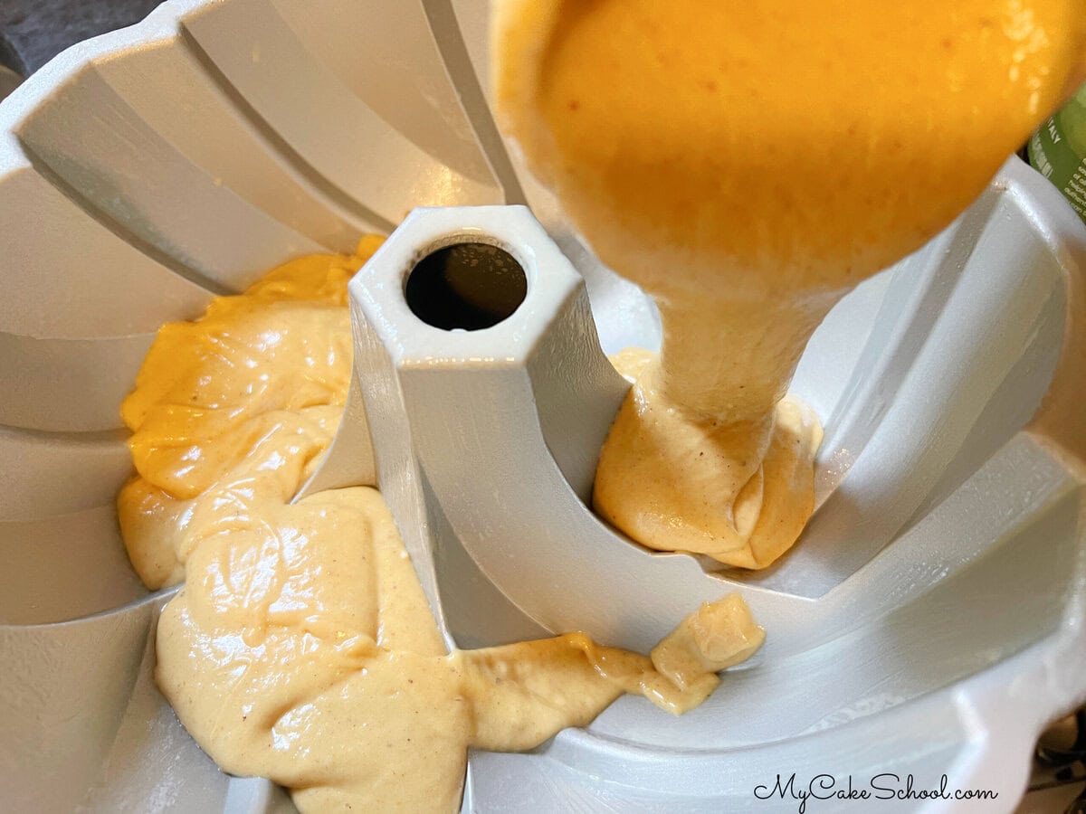 Pouring the pumpkin batter into the prepared bundt pan.
