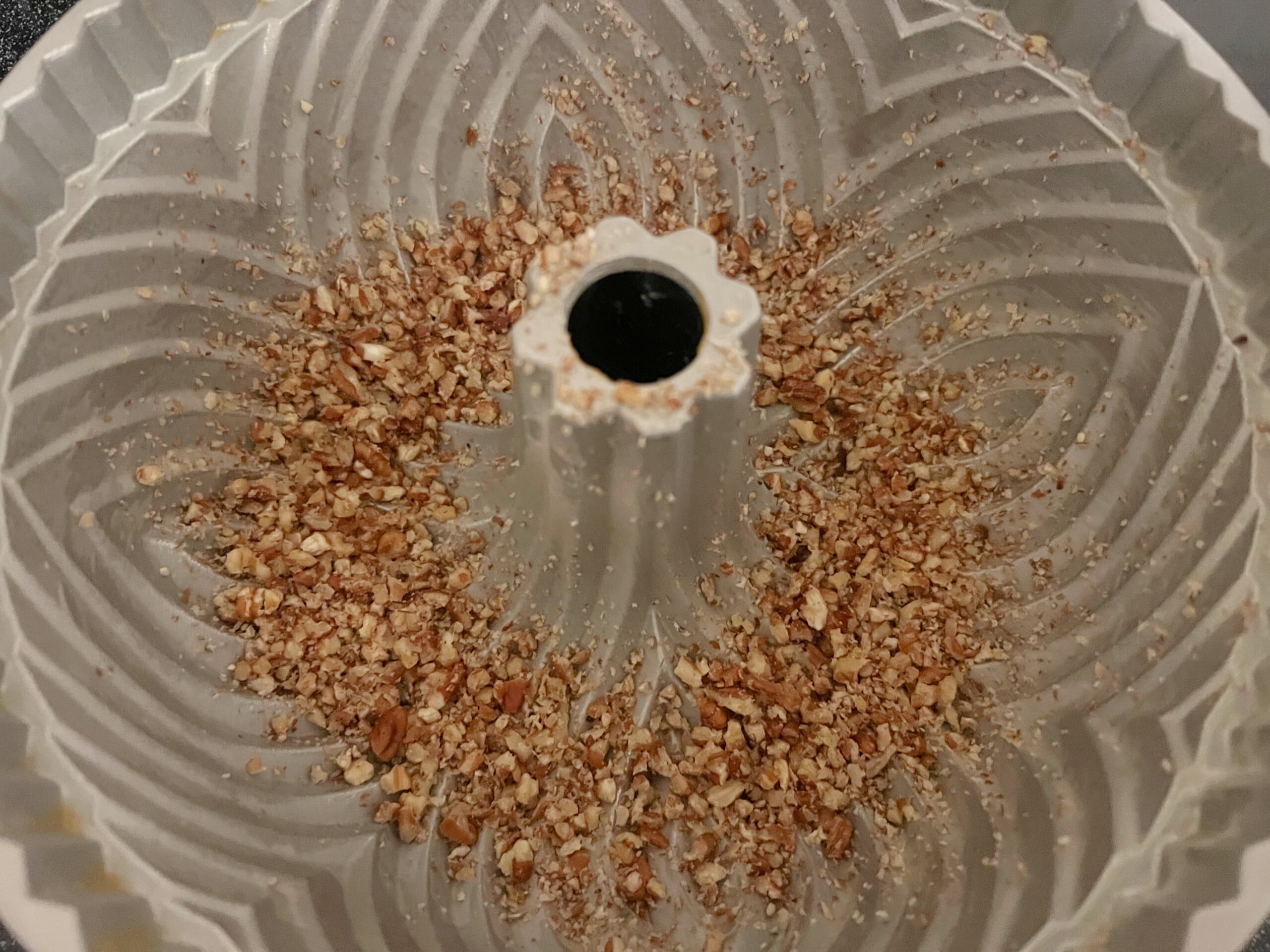 Prepared bundt pan sprinkled in the bottom with chopped pecans.